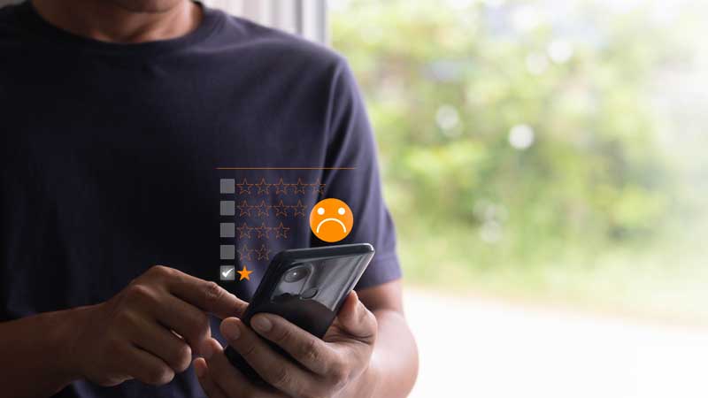 senhor com um telemóvel na mão a fazer uma reclamação